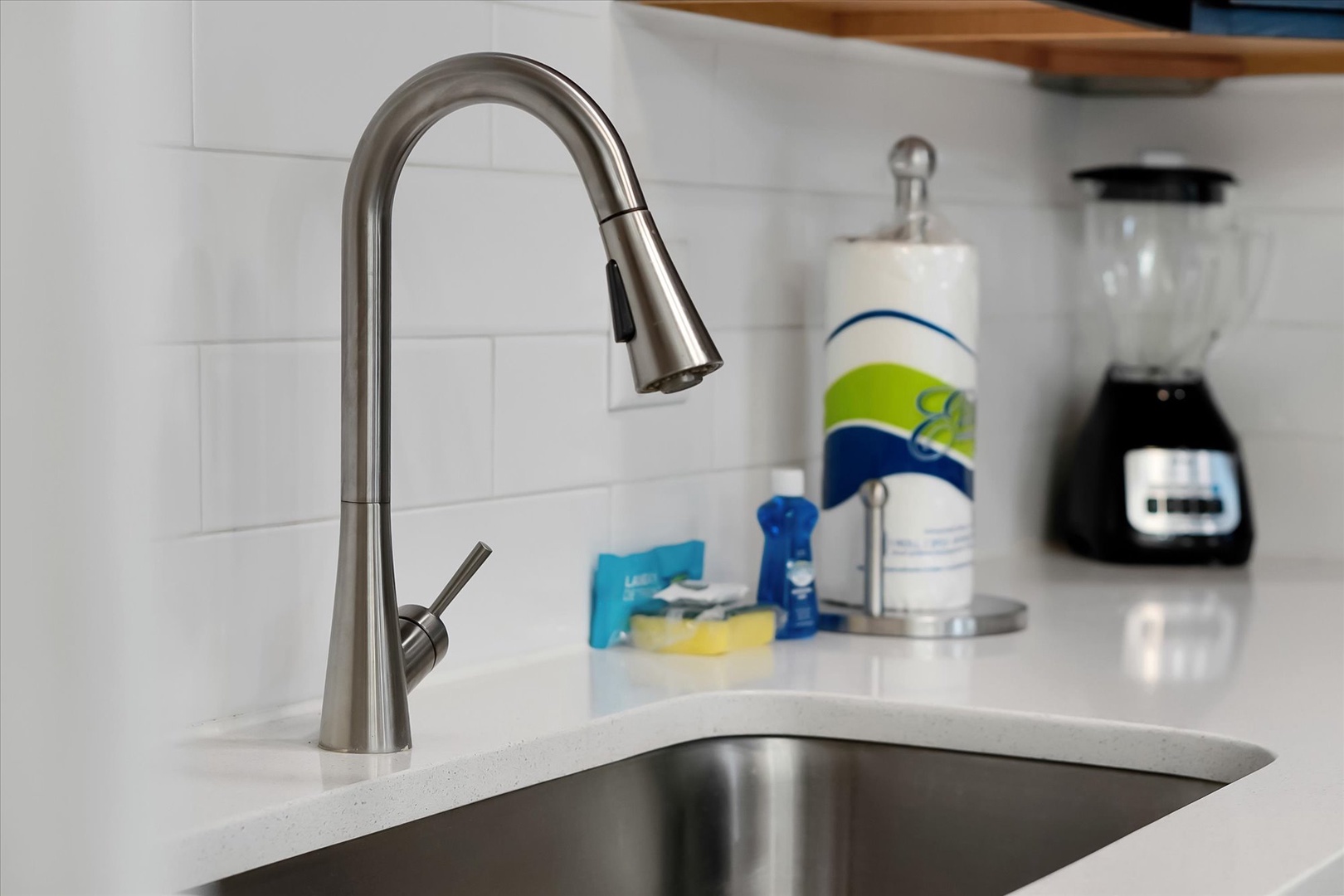 Your modern kitchen features sleek countertops and a pull-down faucet, perfect for preparing meals with style and convenience.