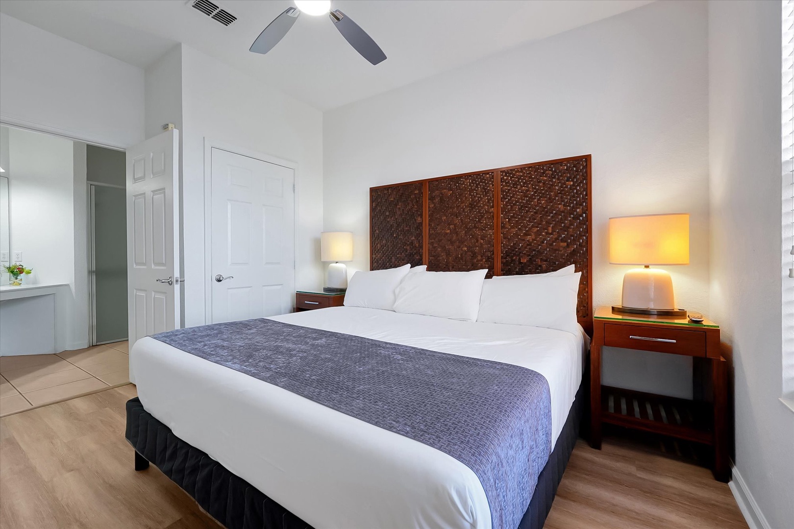 Drift into peaceful sleep in this modern bedroom with elegant woven headboard, plush linens, and gentle lighting.