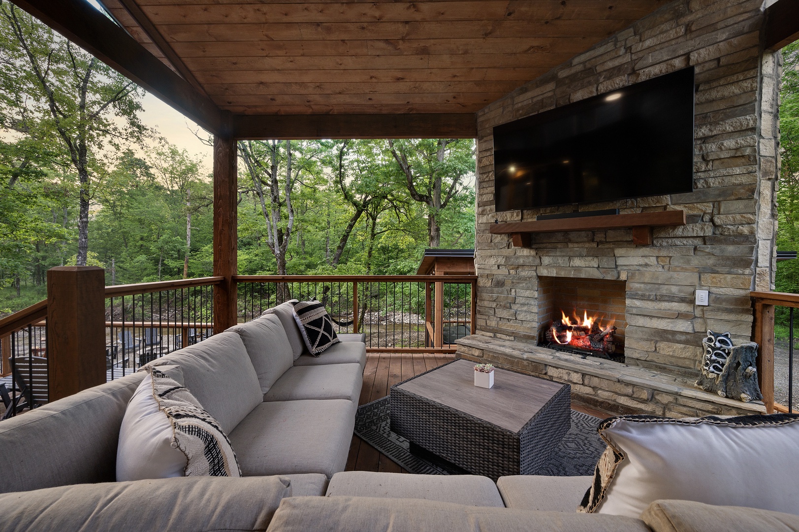 Outdoor entertaining area with sectional seating, gas fireplace, and TV