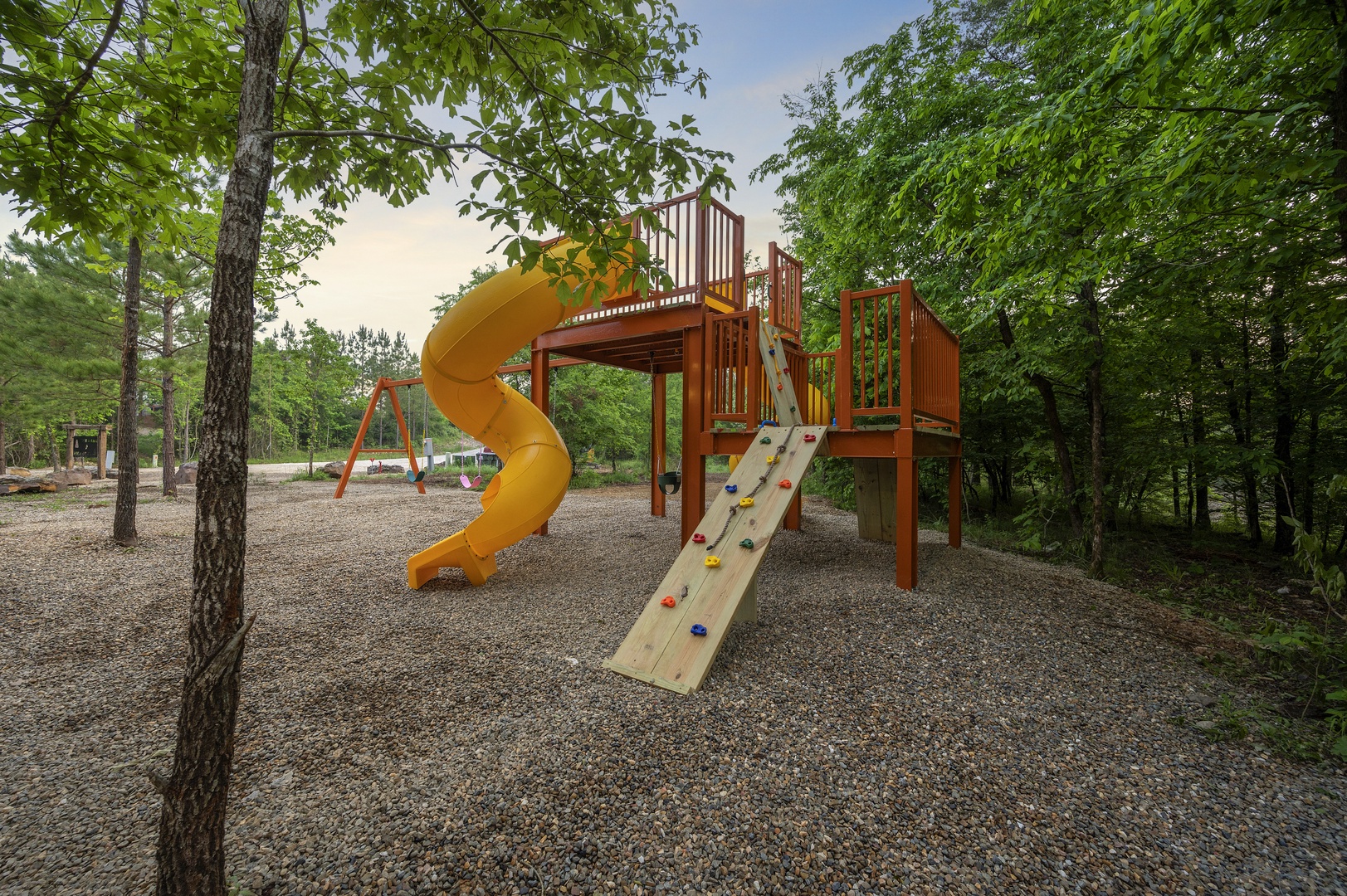 Custom playset with two slides, swings, and rock climbing