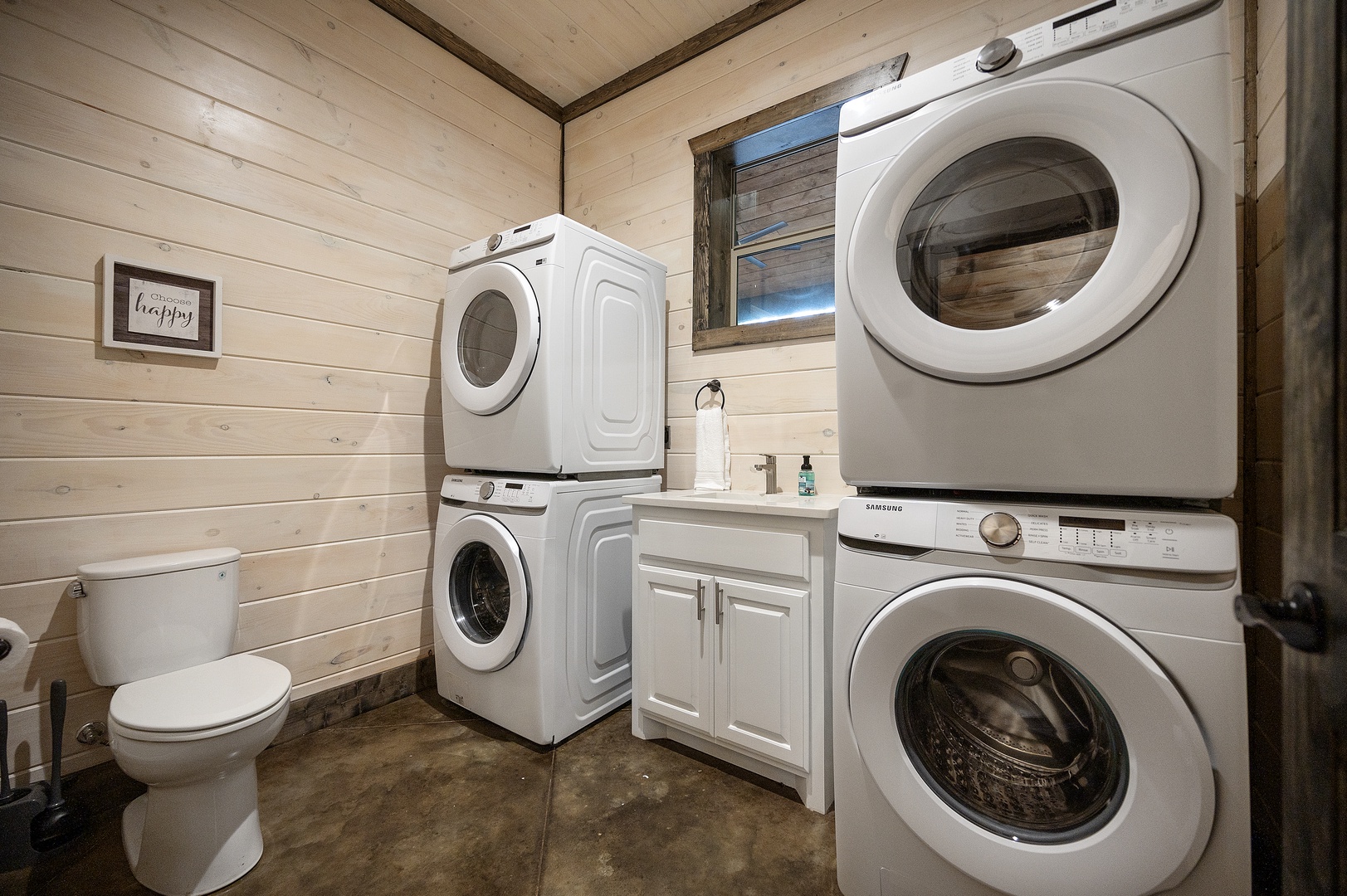 Laundry closet with two full-size sets of washers and dryers and a half bath off the game room