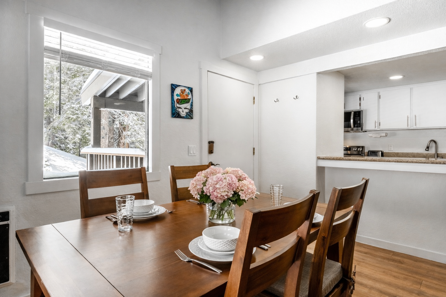 Gather around this warm dining table where fresh flowers await your morning coffee and evening conversations.