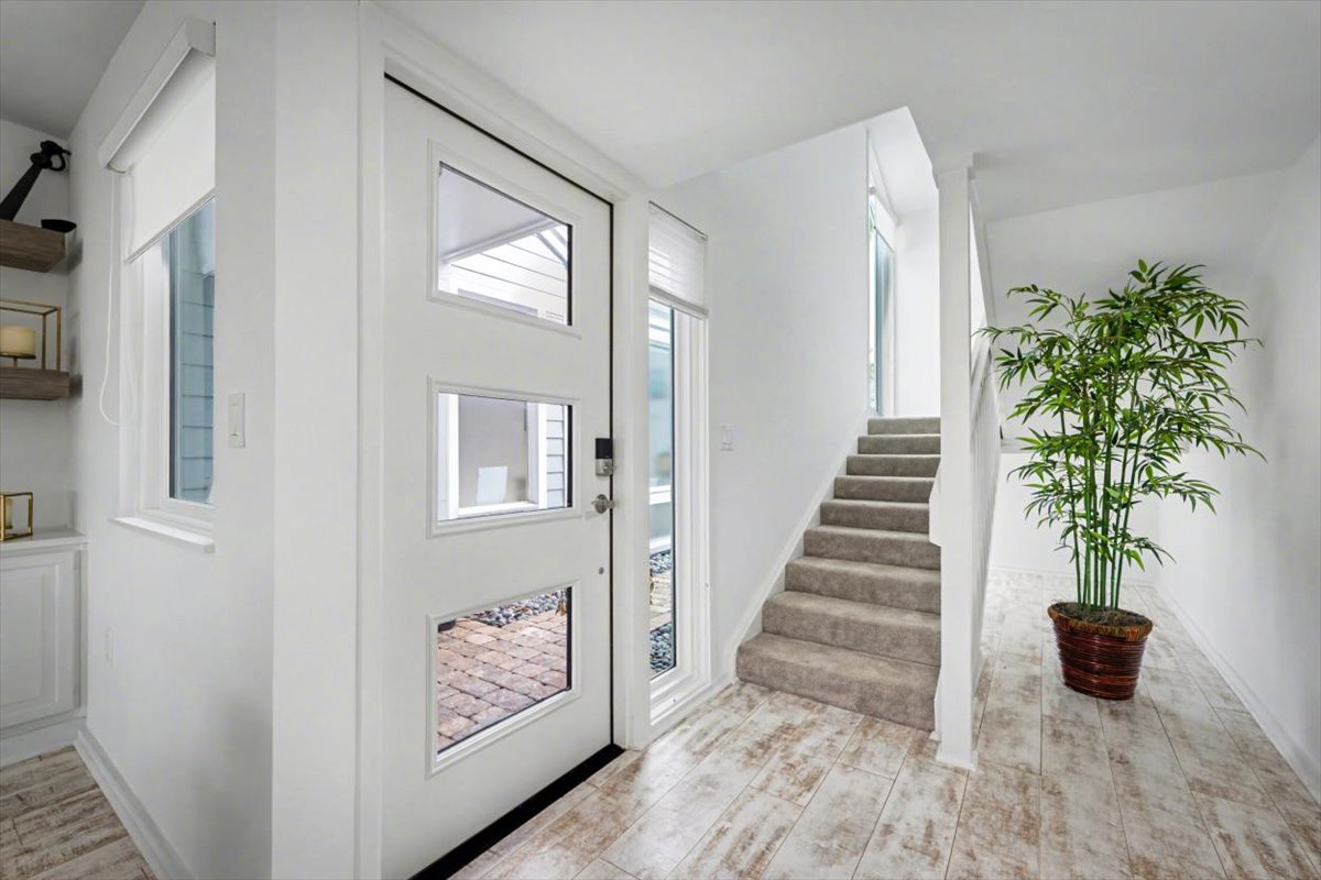Step into your bright, welcoming entryway with soaring ceilings and natural light streaming through modern windows.
