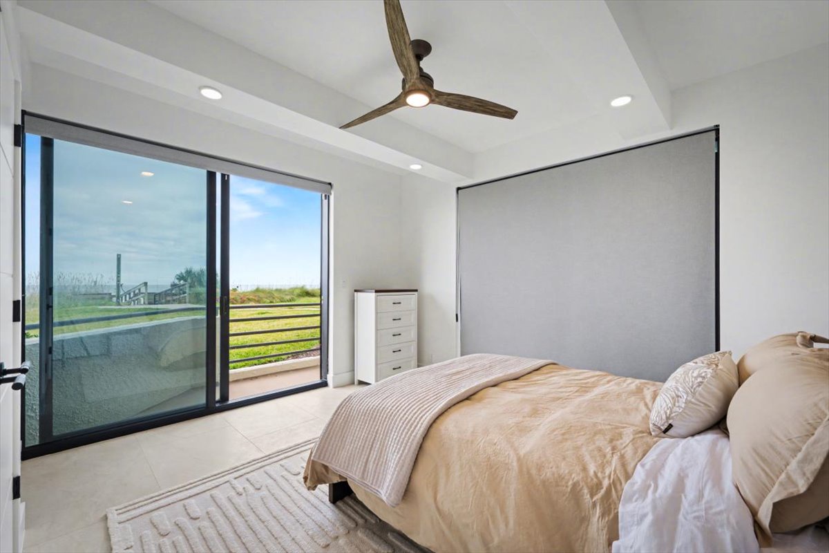 Wake up to panoramic views in your serene bedroom, where soft linens and gentle ceiling fan breezes create the perfect retreat.