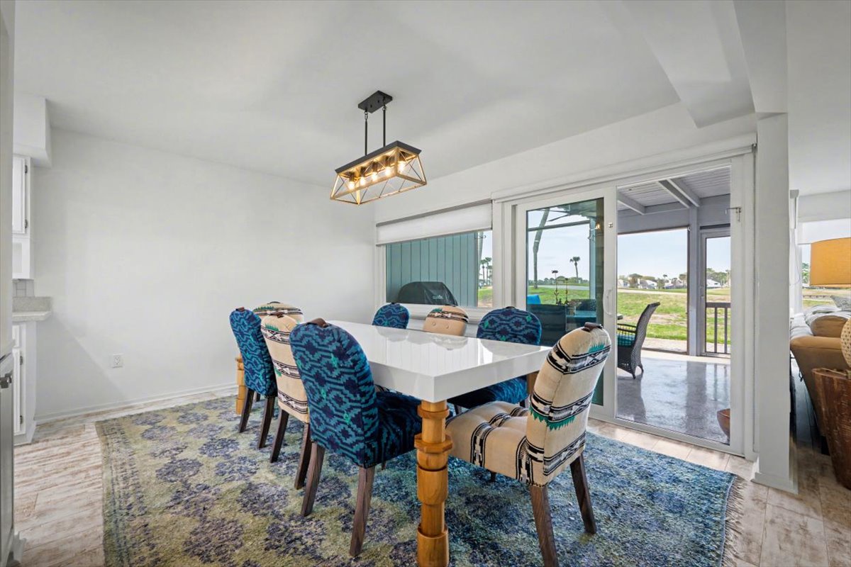 Gather around your elegant dining table where vibrant blue chairs and warm lighting create the perfect atmosphere for memorable meals together.