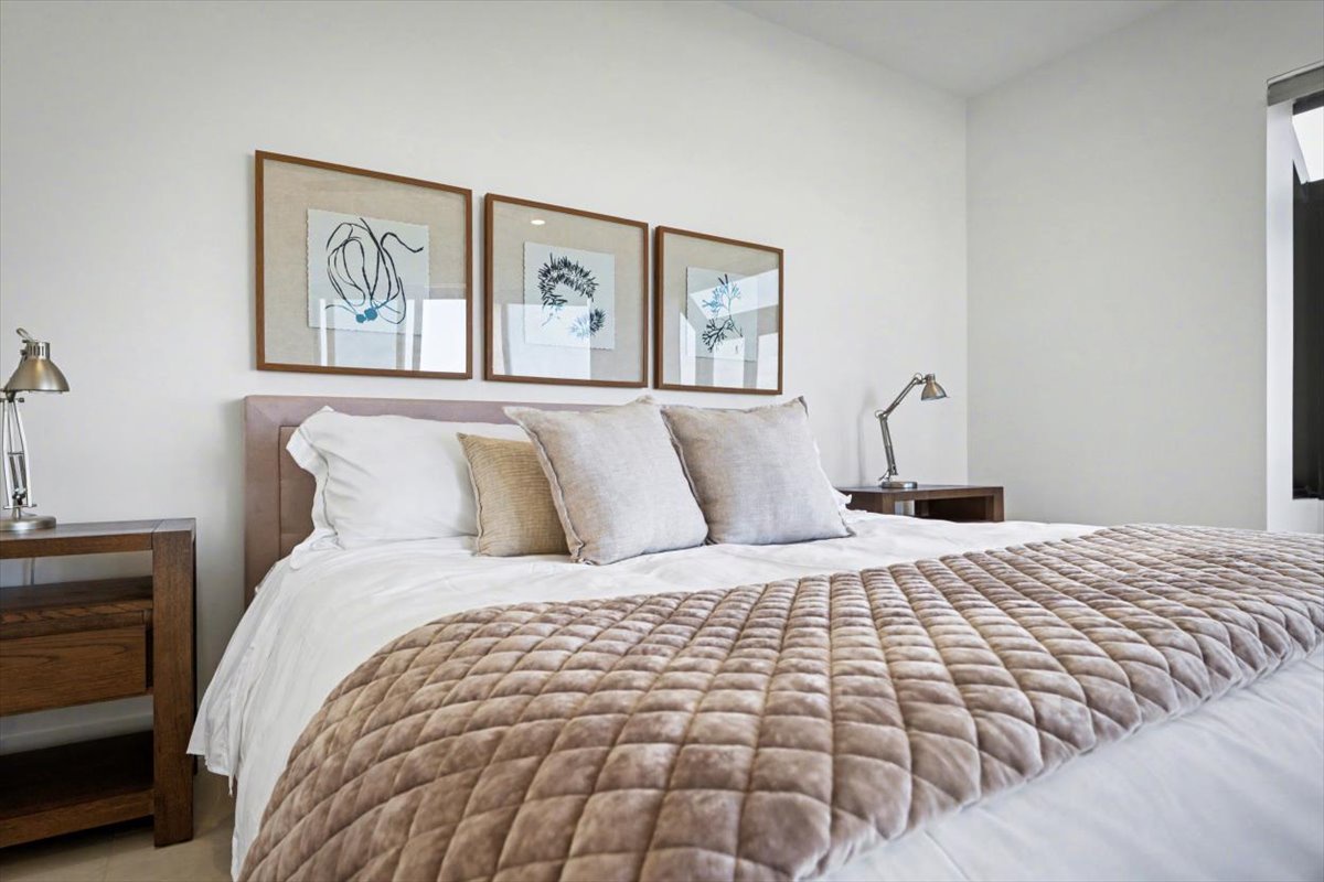 Sink into plush linens and unwind in your thoughtfully designed bedroom, where botanical artwork creates a serene sanctuary for restful nights.