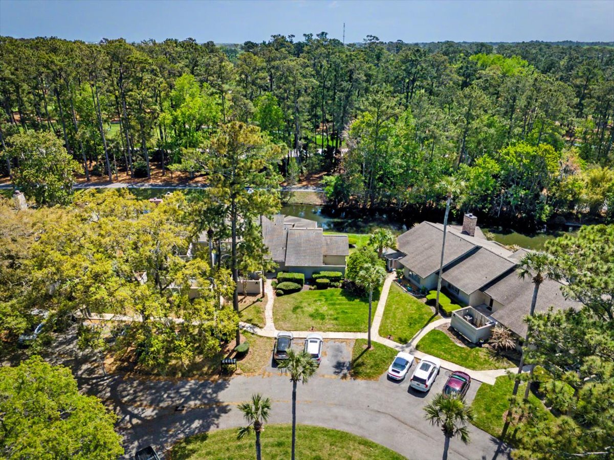 Expansive property nestled among towering trees with multiple buildings, parking, and lush landscaping creating a private forest retreat atmosphere.