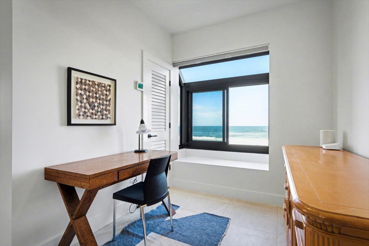 Your private workspace awaits with stunning ocean views through floor-to-ceiling windows, creating the perfect backdrop for productivity or relaxation.
