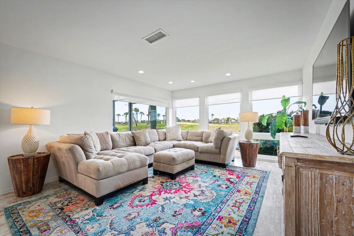 Sink into plush sectional seating while enjoying panoramic views of the green landscape through floor-to-ceiling windows in your bright, stylish living space.