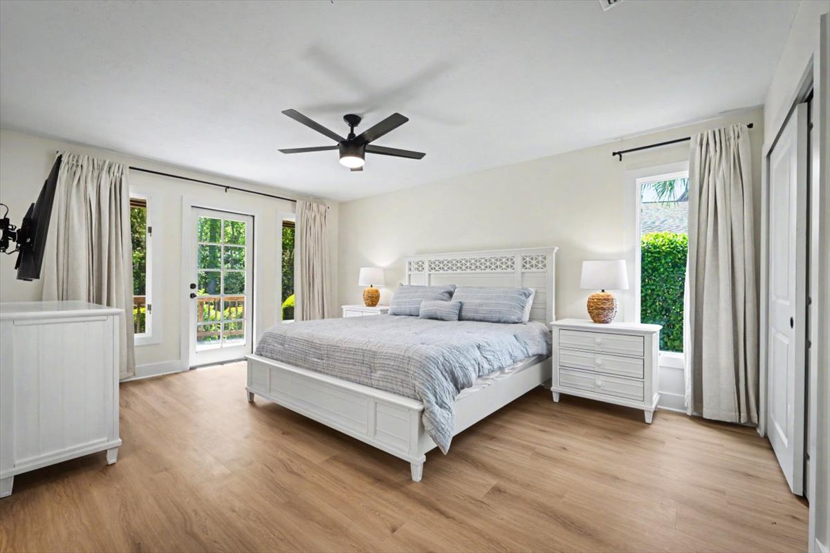 Drift off peacefully in your elegant bedroom with French doors opening to garden views and a gentle ceiling fan overhead.