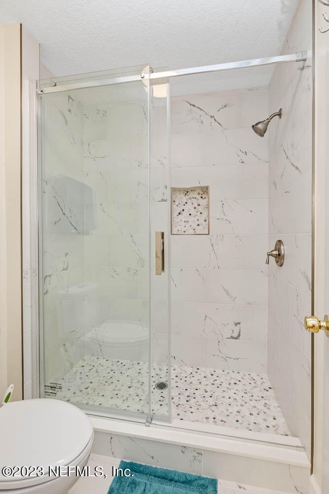 Step into your spa-like walk-in shower, where elegant marble-look tile and a mosaic floor create a serene retreat you'll never want to leave.