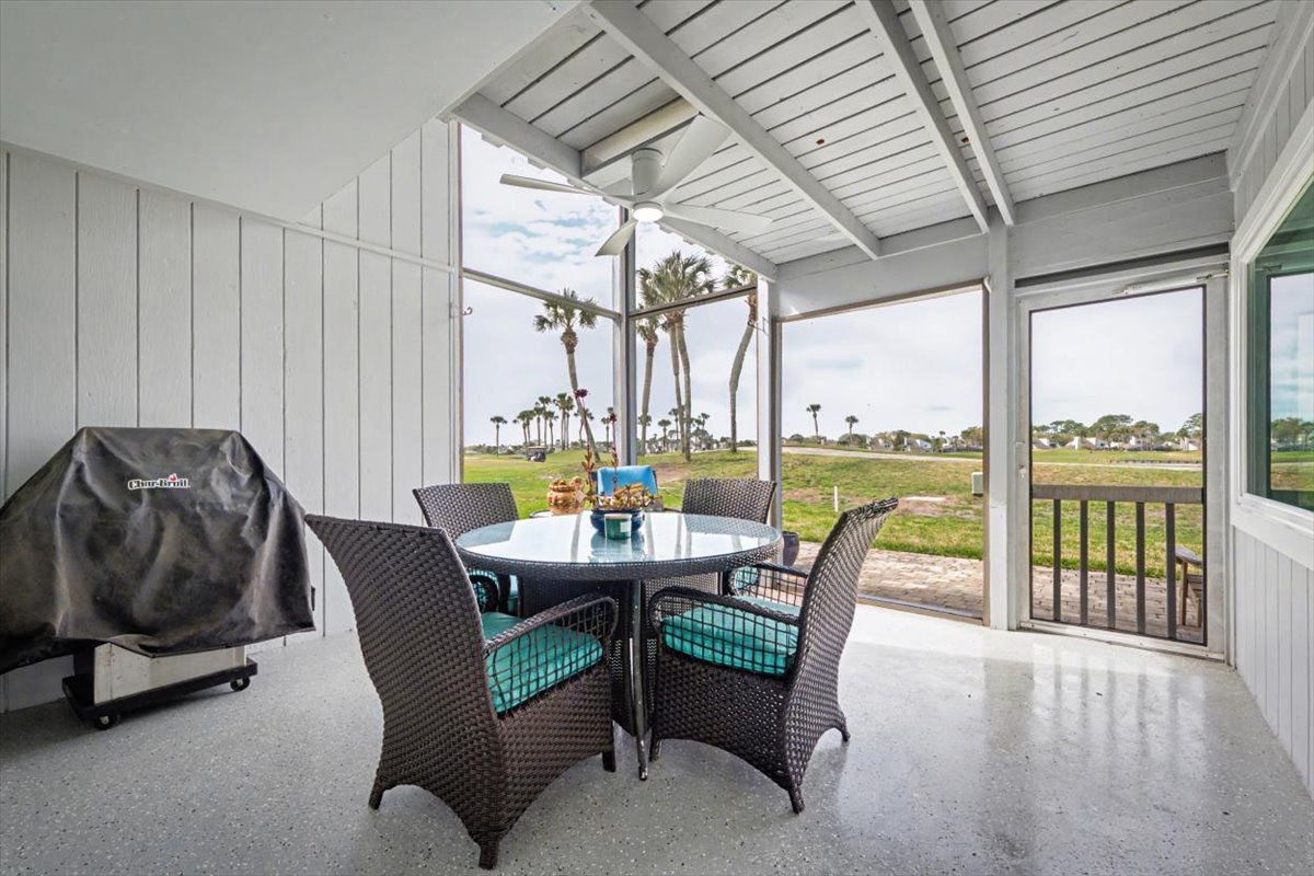 Your screened patio offers perfect indoor-outdoor dining with wicker chairs, ceiling fan, and golf course views.