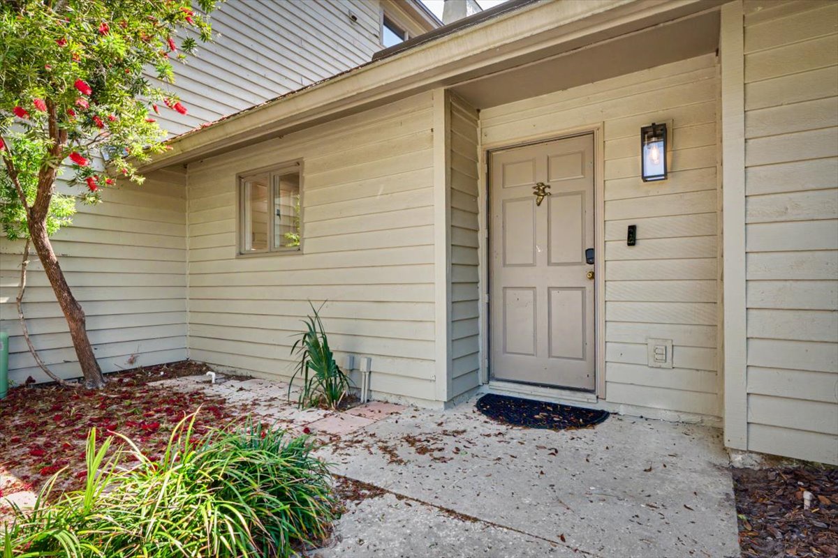 A welcoming entrance surrounded by lush landscaping and vibrant blooming plants creates a charming first impression for your arrival.