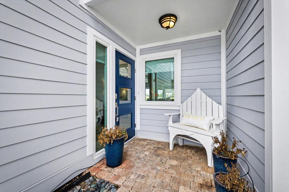 Step into your welcoming entrance where coastal charm meets comfort with a charming white bench and cheerful blue accents greeting you home.
