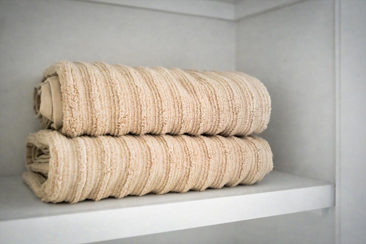 Soft, plush towels await you on pristine white shelving, promising cozy comfort after your shower.