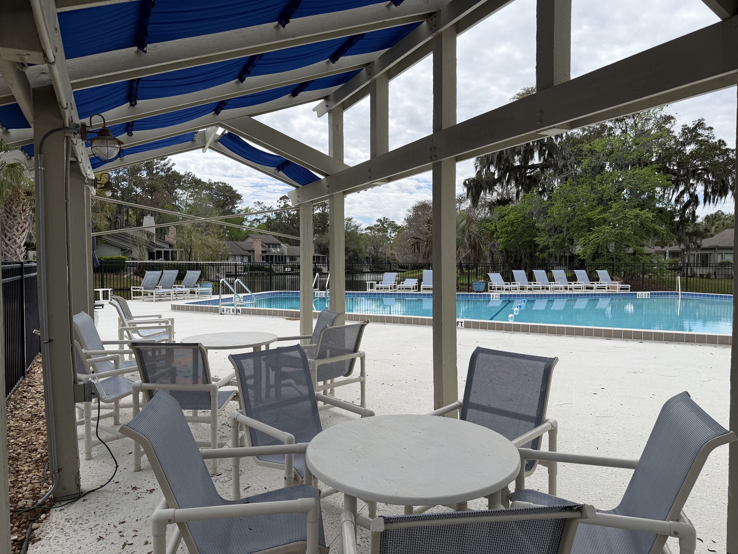 Relax under the covered pavilion with pool views and comfortable outdoor dining for your perfect day by the water.