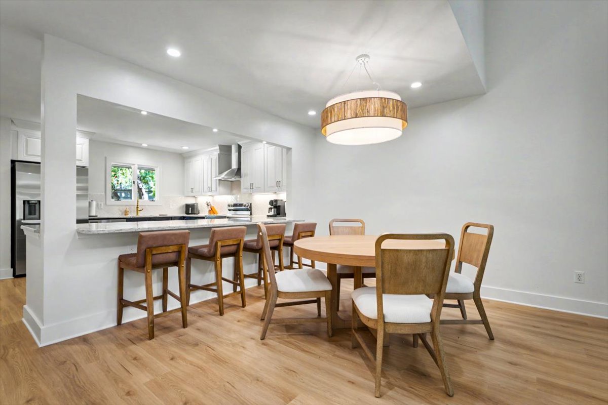 Gather around your elegant dining table or chat at the kitchen bar beneath warm pendant lighting in this thoughtfully designed space.
