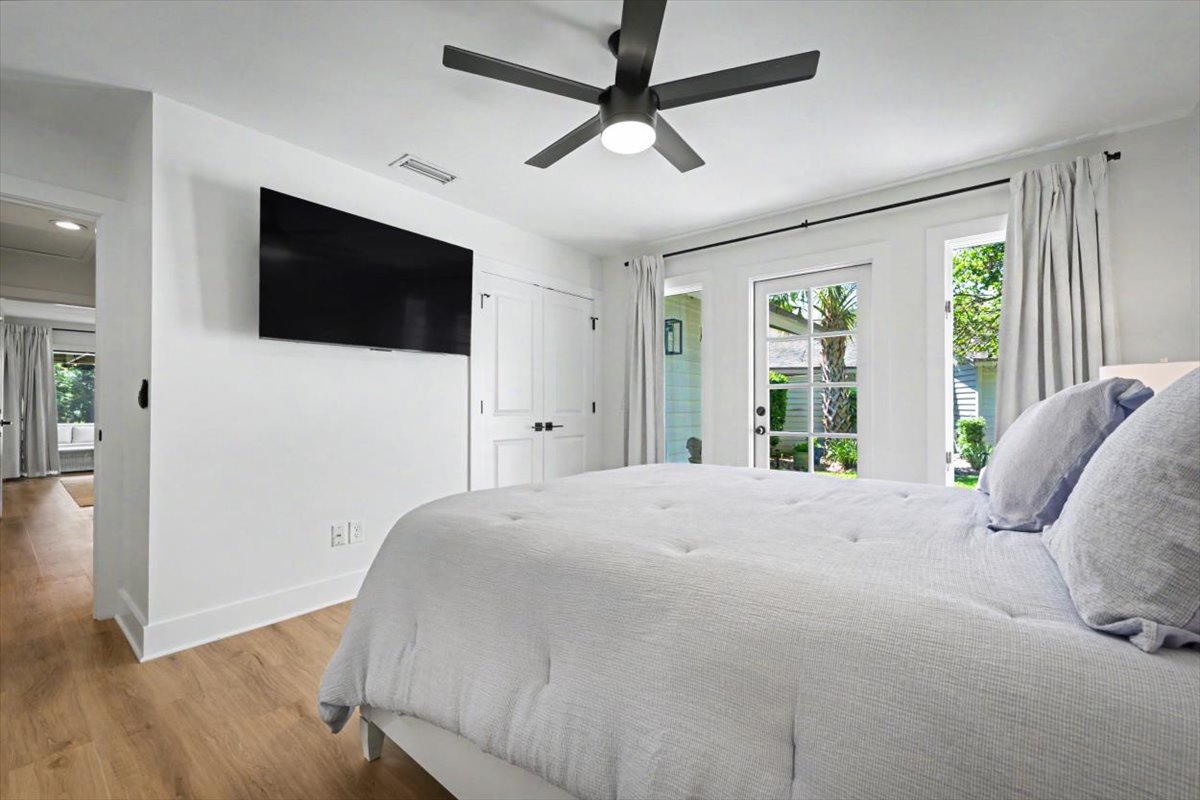 Sink into this serene bedroom where soft linens, gentle ceiling fan breezes, and natural light create your perfect retreat sanctuary.