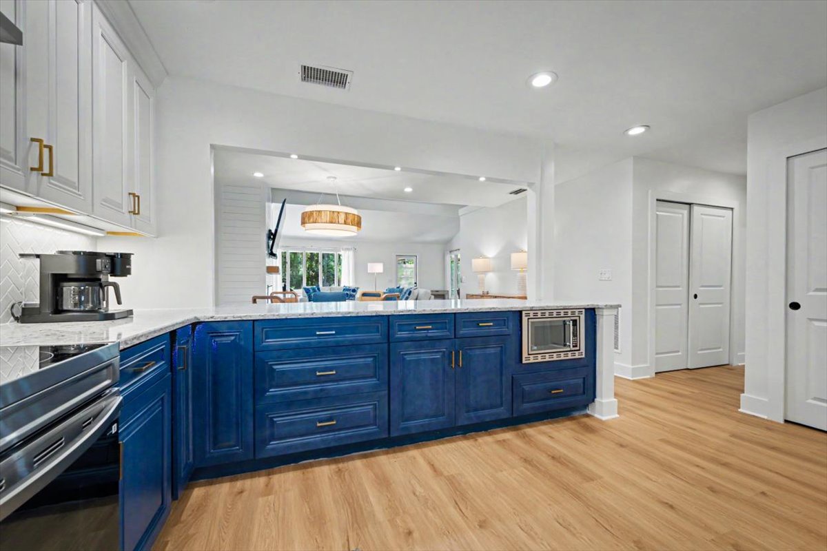 Your gourmet kitchen features striking blue cabinets, pristine white countertops, and premium appliances—perfect for creating memorable meals during your stay.