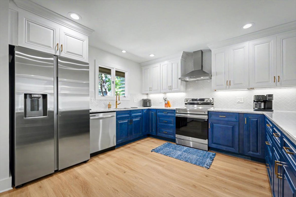 Your spacious gourmet kitchen awaits with modern appliances, elegant blue and white cabinetry, and everything you need to create memorable meals together.