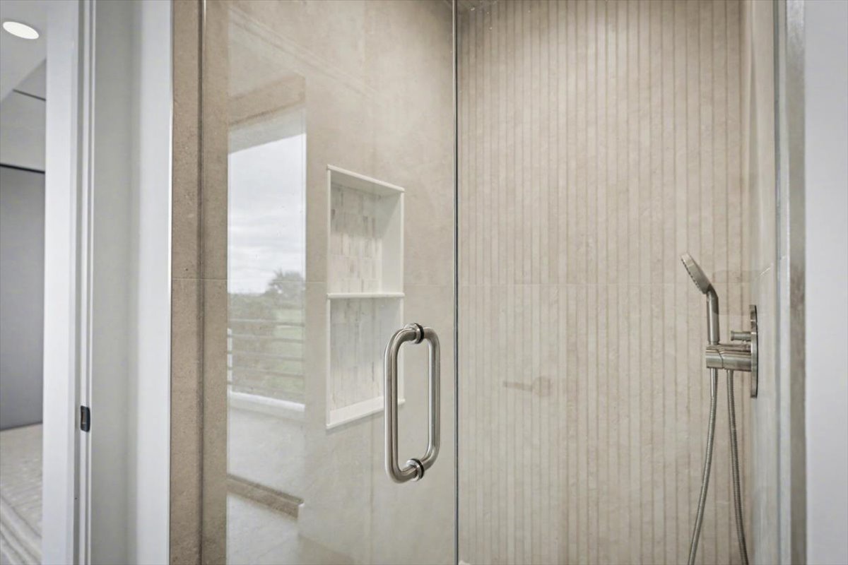Step into your spa-like glass shower with elegant tile work and modern fixtures for a refreshing start to your day.