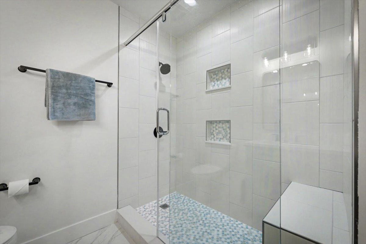 Step into your spa-like glass-enclosed shower with beautiful mosaic details and rainfall showerhead for the perfect start to each day.
