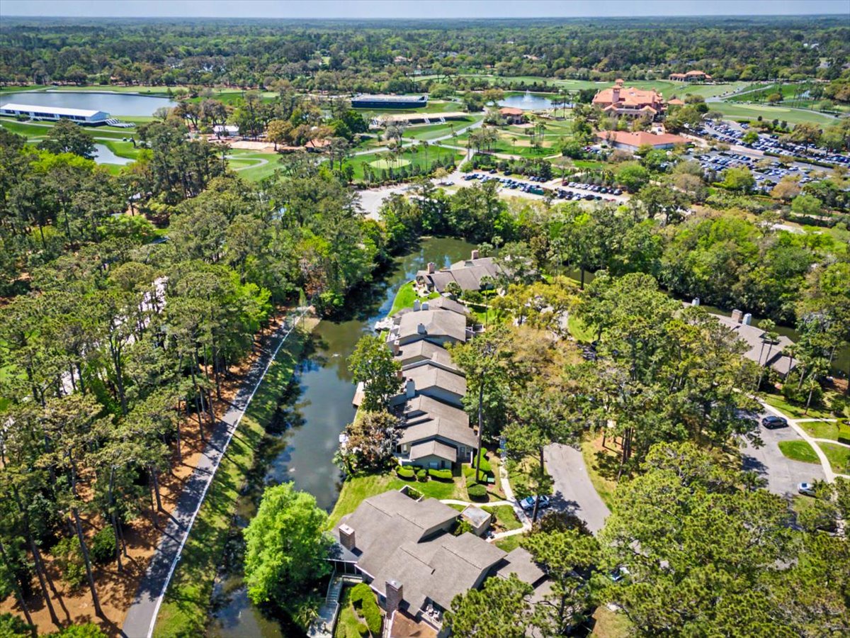 Aerial view of a peaceful residential community surrounded by lush forests, with golf course facilities and recreational amenities nearby.
