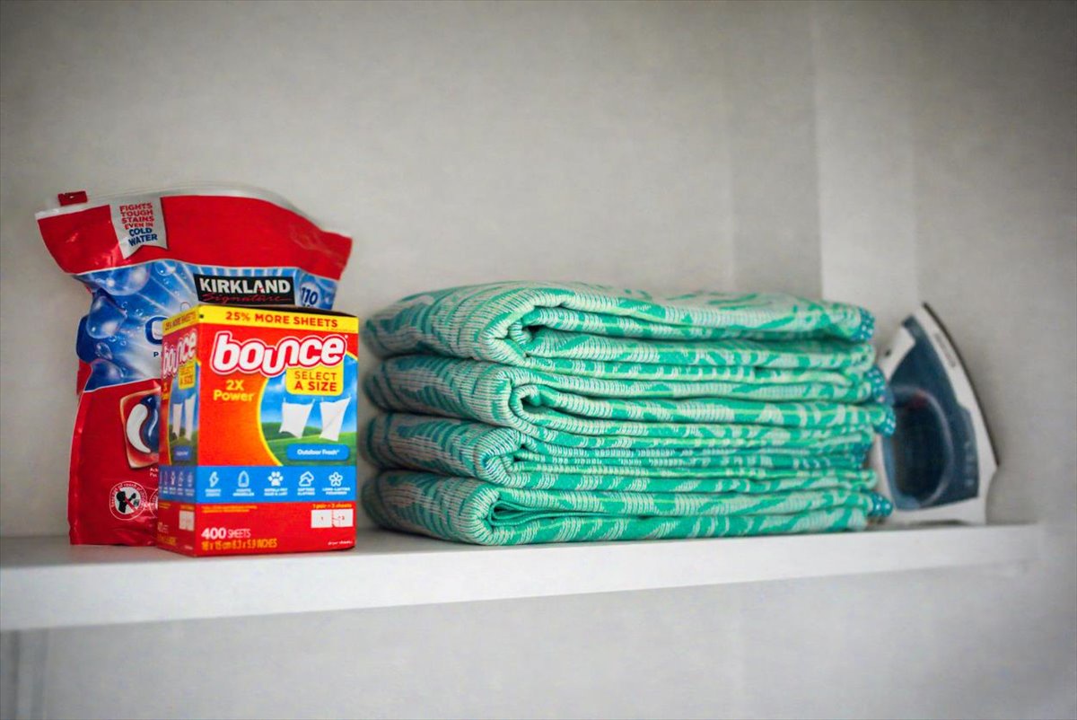 Your laundry essentials are ready - fresh towels, detergent, and a convenient iron await your use.