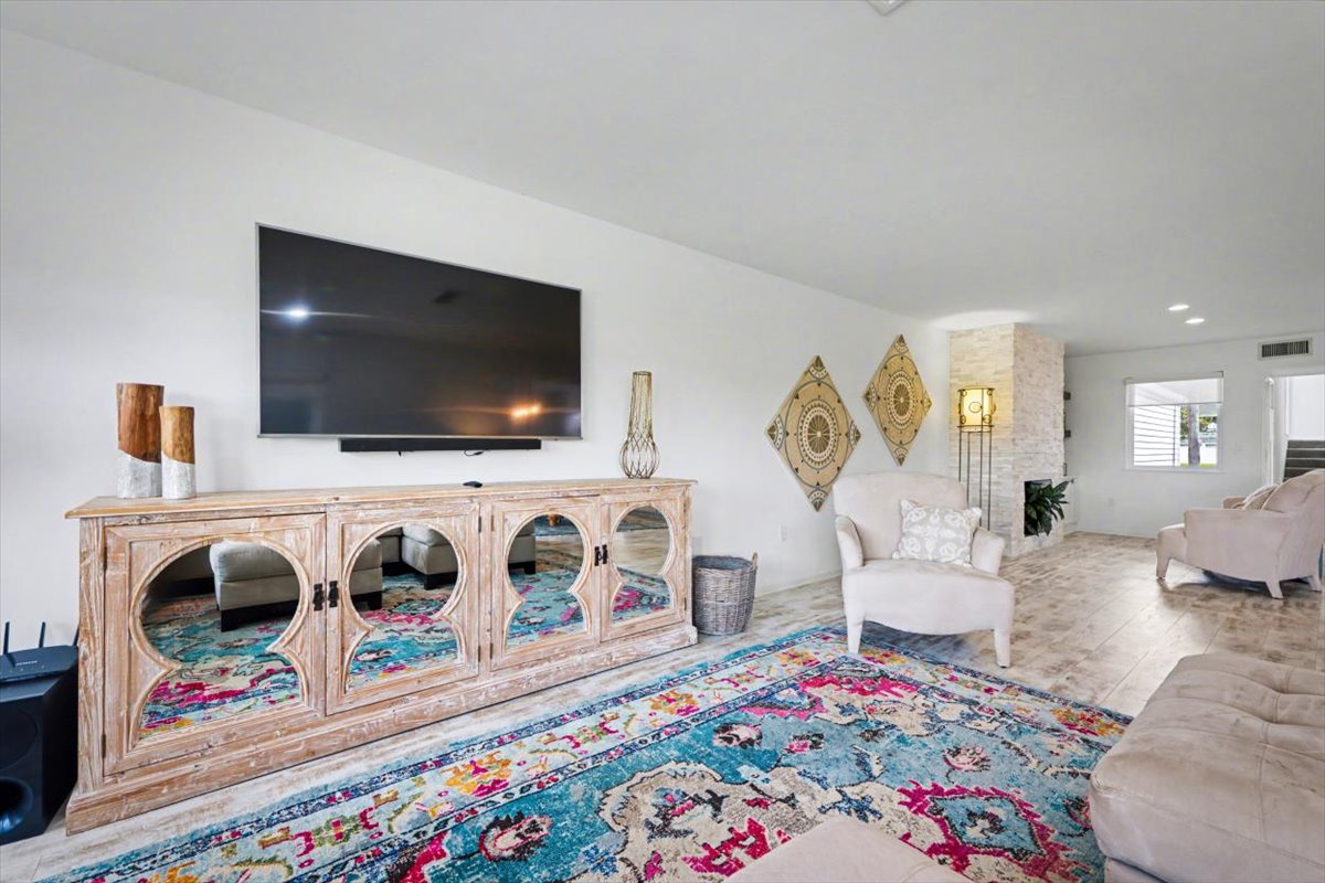 Unwind in your stylish living space featuring plush seating, vibrant artwork, and a large TV for cozy evenings together.