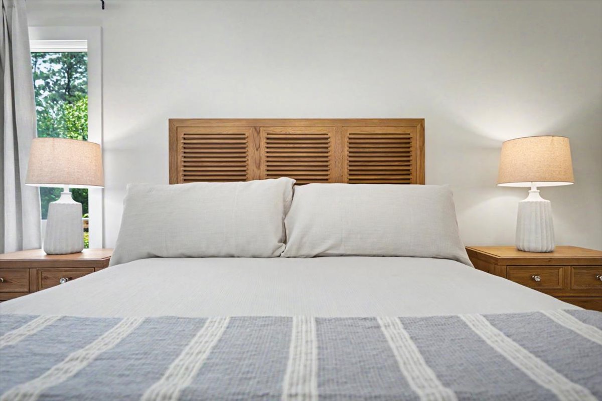 Unwind in your serene bedroom with crisp white linens and warm wood accents creating perfect harmony for restful nights.