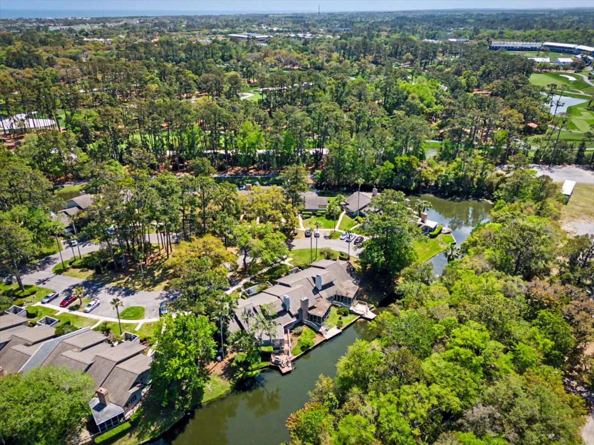 Scenic aerial view showcasing a tranquil waterfront neighborhood nestled among lush greenery with winding canals and nearby recreational areas.