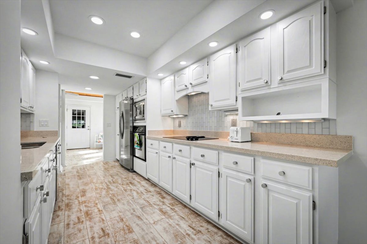 Your spacious galley kitchen features gleaming white cabinets, granite counters, and stainless appliances—perfect for preparing memorable meals during your stay.