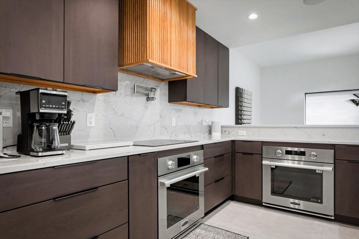 Your fully equipped kitchen awaits with premium appliances, marble counters, and warm wood accents for memorable meal prep moments.