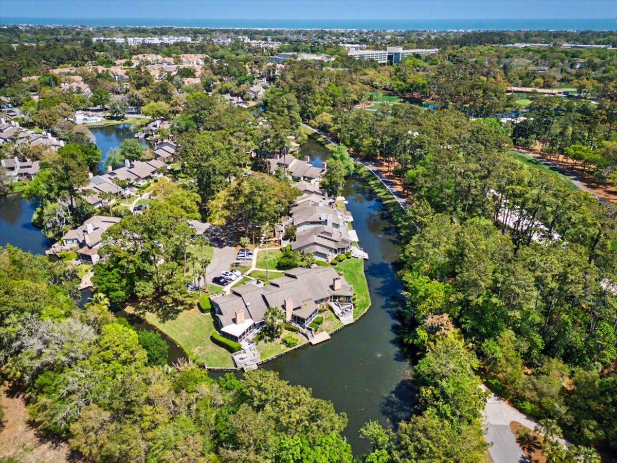 Aerial view showcasing waterfront properties nestled along a scenic river, surrounded by lush trees and peaceful residential neighborhoods.