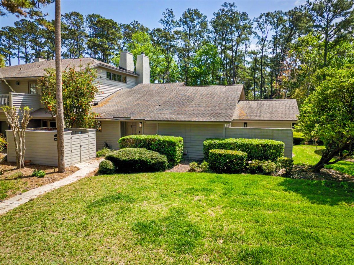 Contemporary property nestled among mature trees with manicured landscaping and peaceful wooded surroundings.