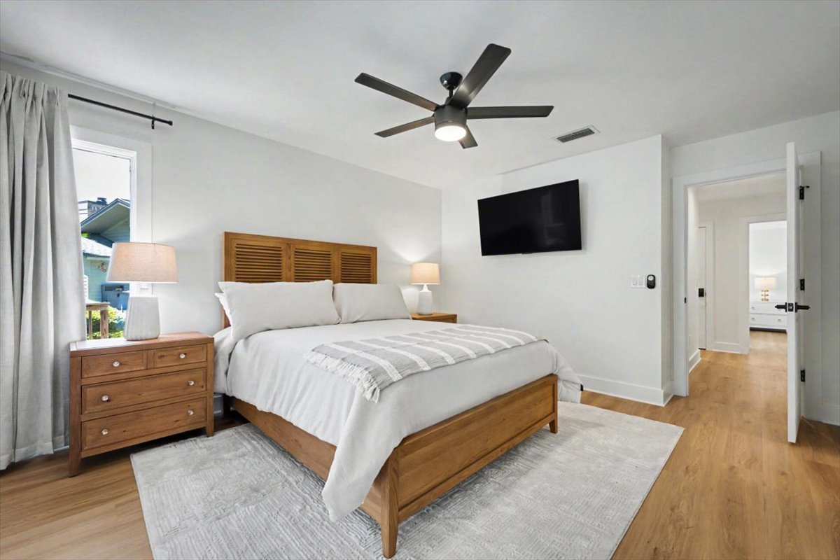 Your serene bedroom sanctuary features a plush king bed, warm wood furnishings, and modern amenities for ultimate relaxation.