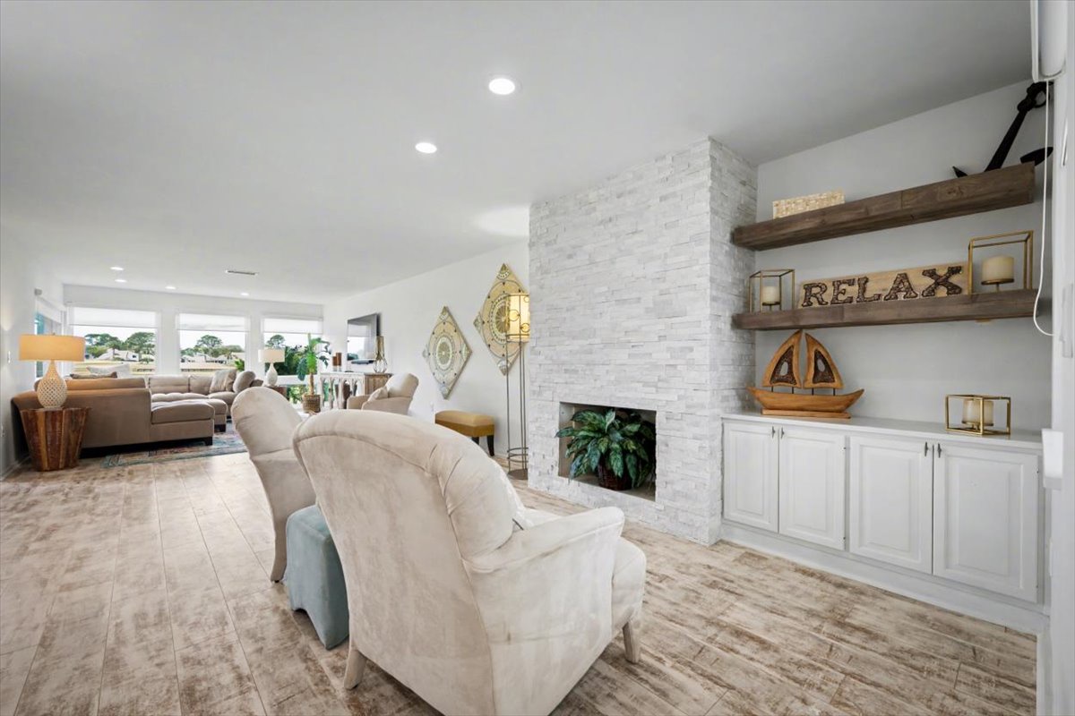 Sink into plush seating by your elegant stone fireplace, where rustic shelves invite you to truly relax in this bright, sophisticated living space.