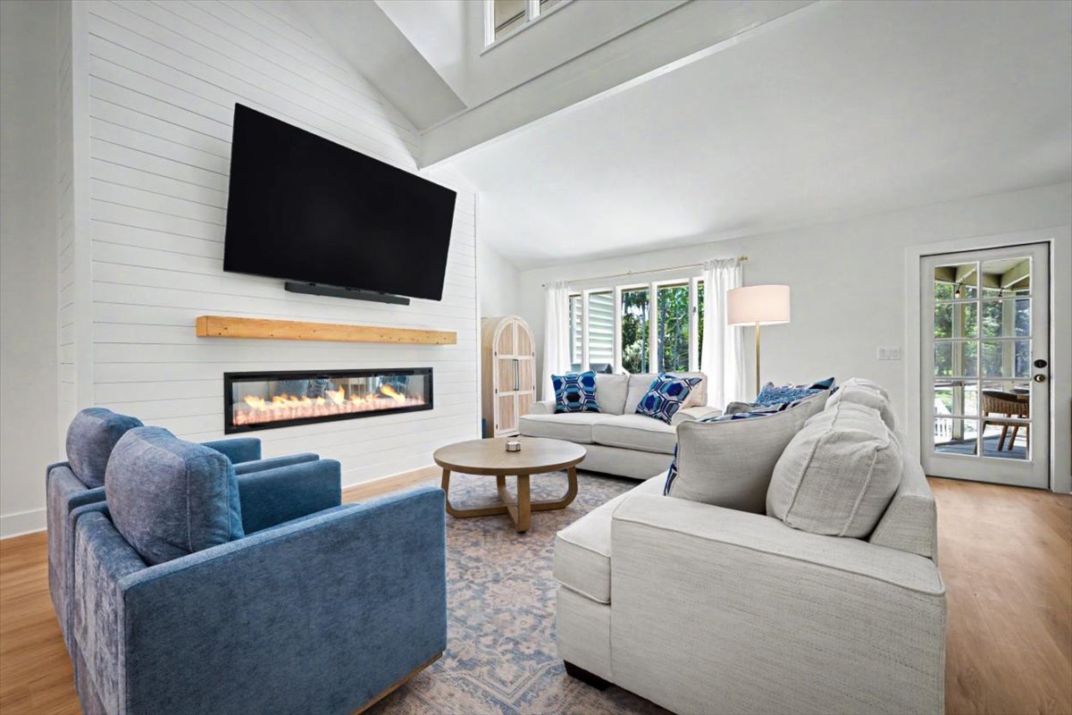 Gather around the cozy fireplace in your stylish living room, where plush seating and warm ambiance create the perfect spot for relaxing evenings together.