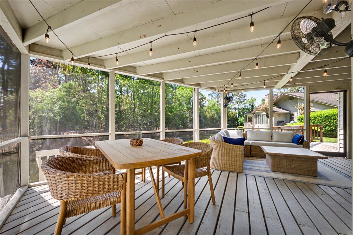 Your screened porch offers a perfect blend of indoor comfort and outdoor charm, with wicker seating and garden views.