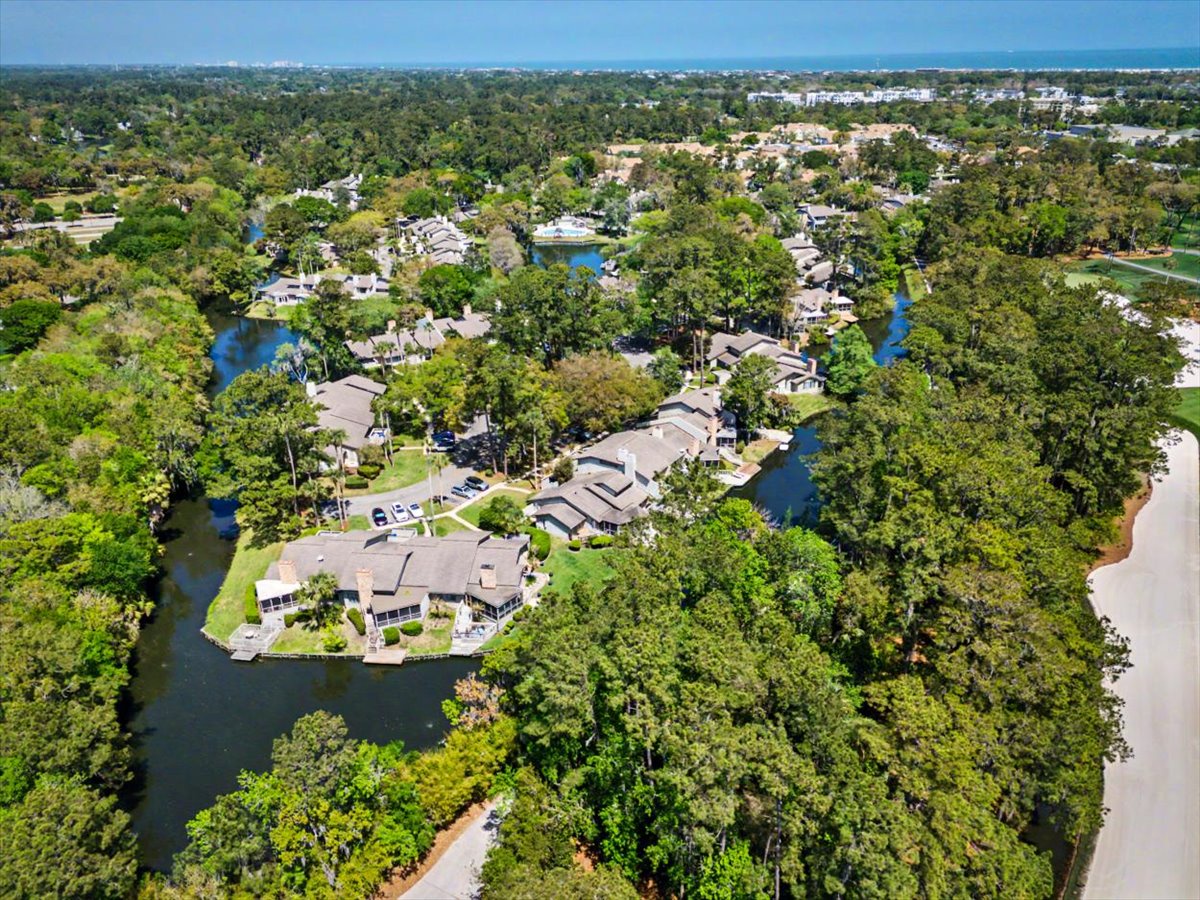 Aerial view of the resort community nestled among lush trees with waterway access and natural surroundings.