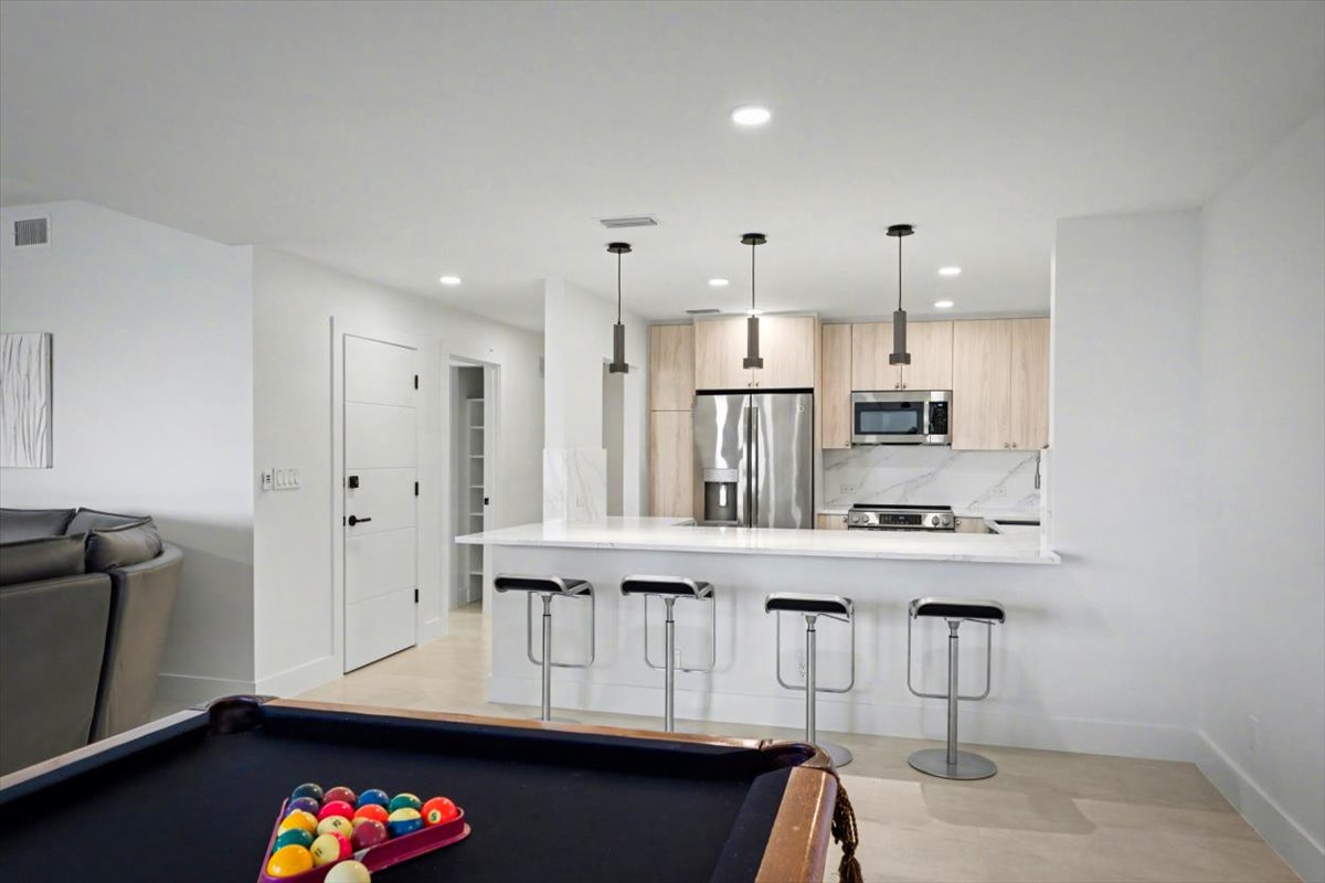 Step into your open-concept haven where sleek kitchen meets entertainment. Challenge friends at the pool table, then gather at the breakfast bar for morning coffee.