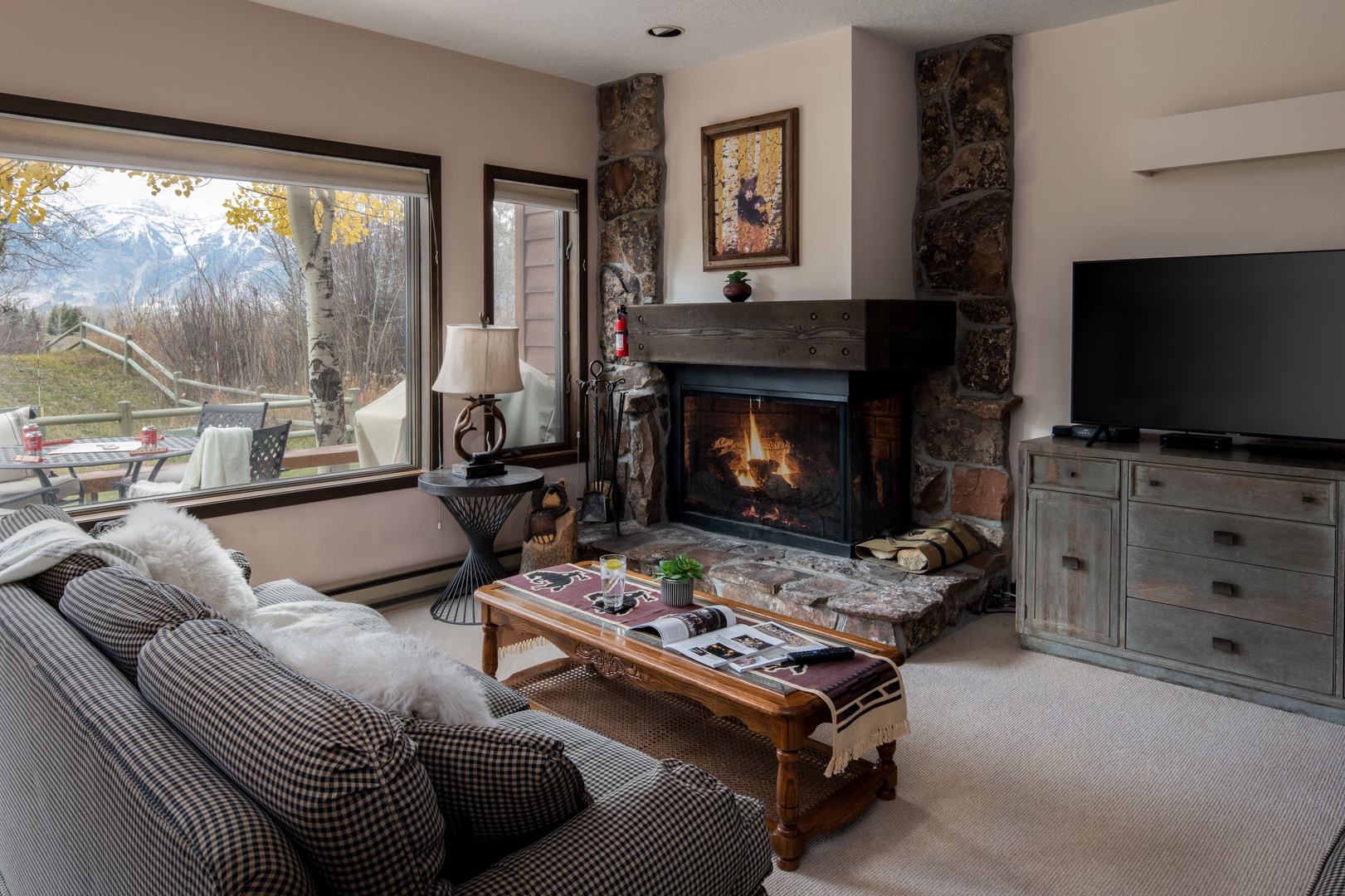 Cozy living room with Teton range views, a wood burning fireplace and a queen sleeper sofa