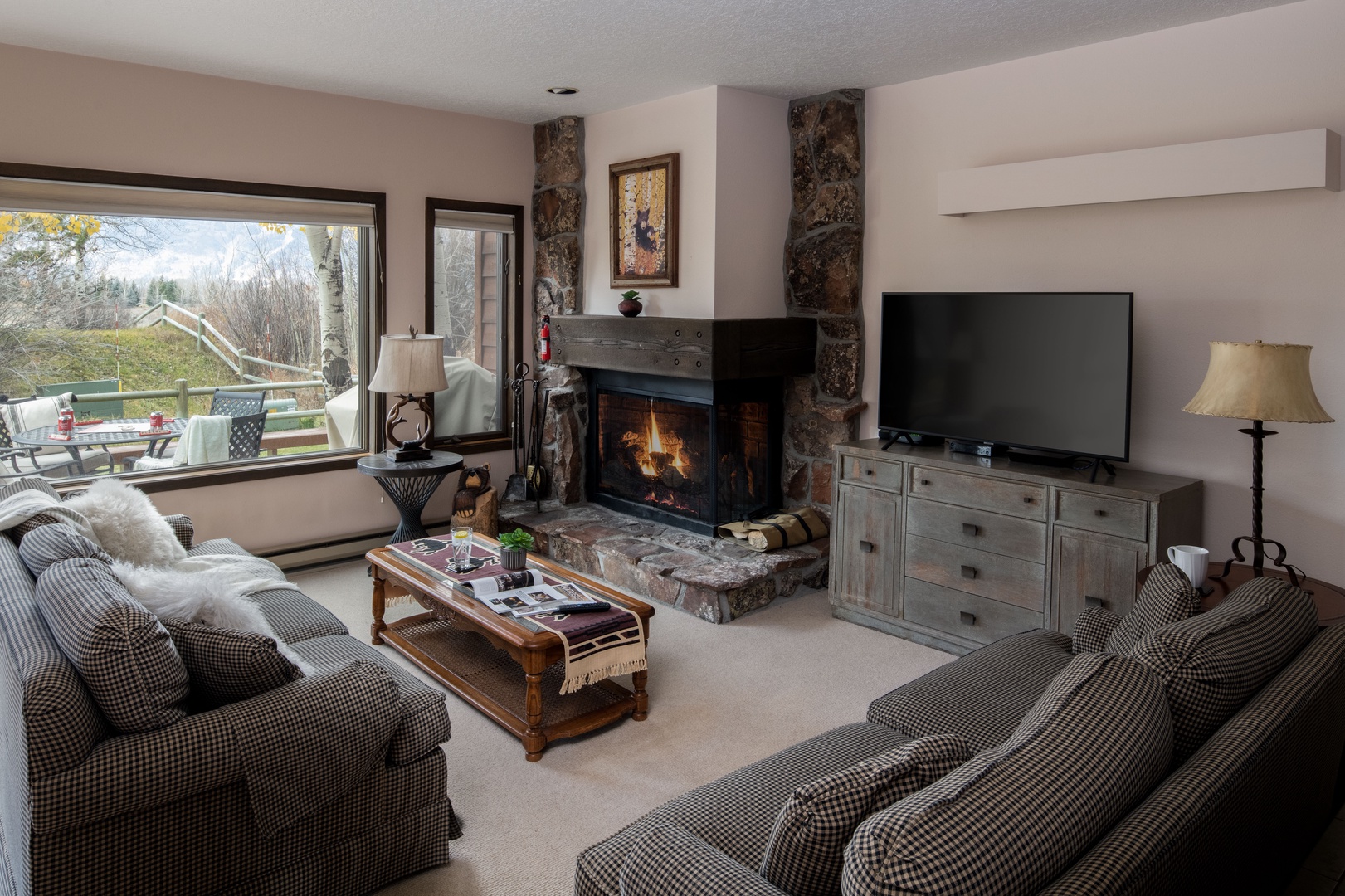 Cozy living room with Teton range views, a wood burning fireplace and a queen sleeper sofa