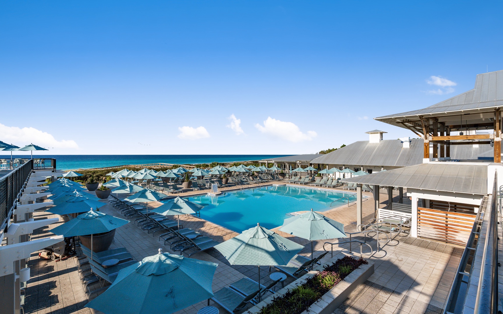Stunning beachfront resort with sparkling pool overlooking pristine turquoise waters and white sand beach.