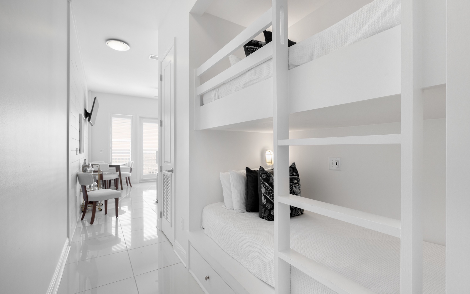 Your modern white bunk bed sanctuary offers space-saving comfort with built-in storage and individual reading lights for peaceful nights.