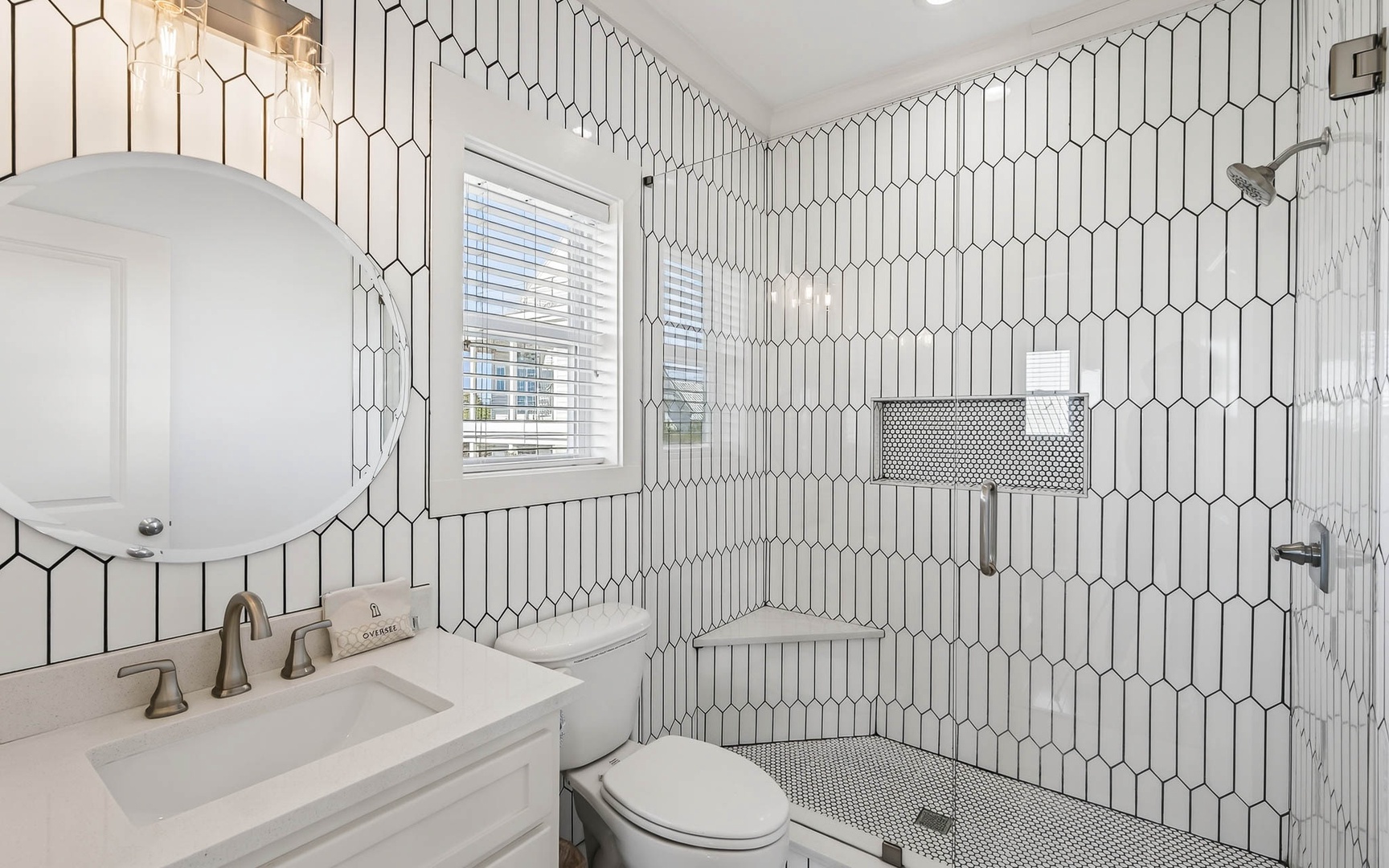 Step into your stylish bathroom featuring elegant geometric tile walls and modern fixtures for your comfort.