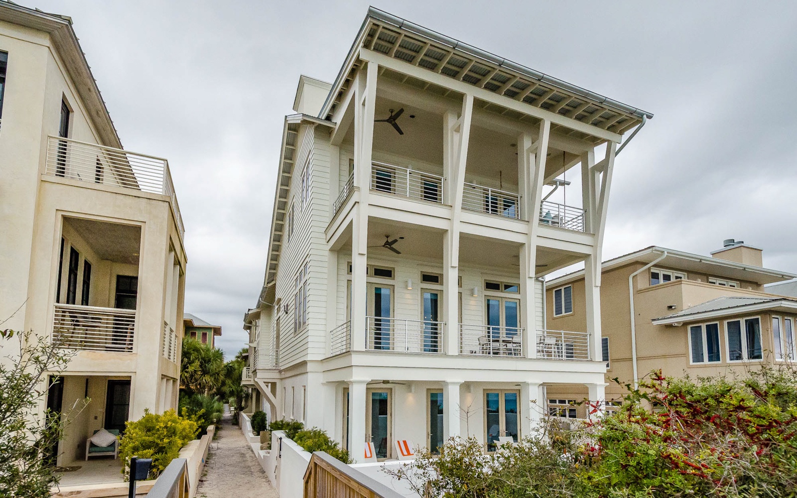 Elegant three-story beach house with spacious covered porches and modern coastal architecture in a peaceful residential setting.
