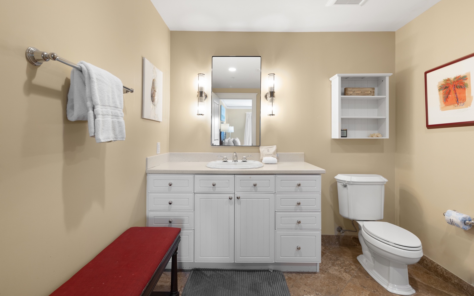 Step into your spacious bathroom featuring white cabinetry, elegant lighting, and plush towels for your comfort.
