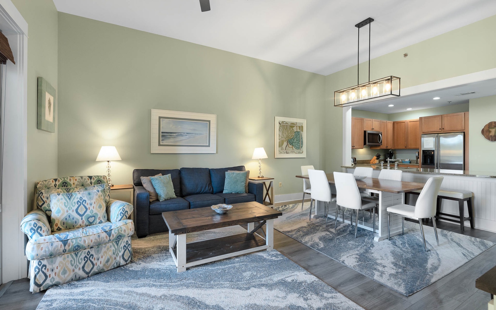 Settle into your spacious open-concept living area where coastal blues meet warm wood tones, creating the perfect space to unwind after your adventures.