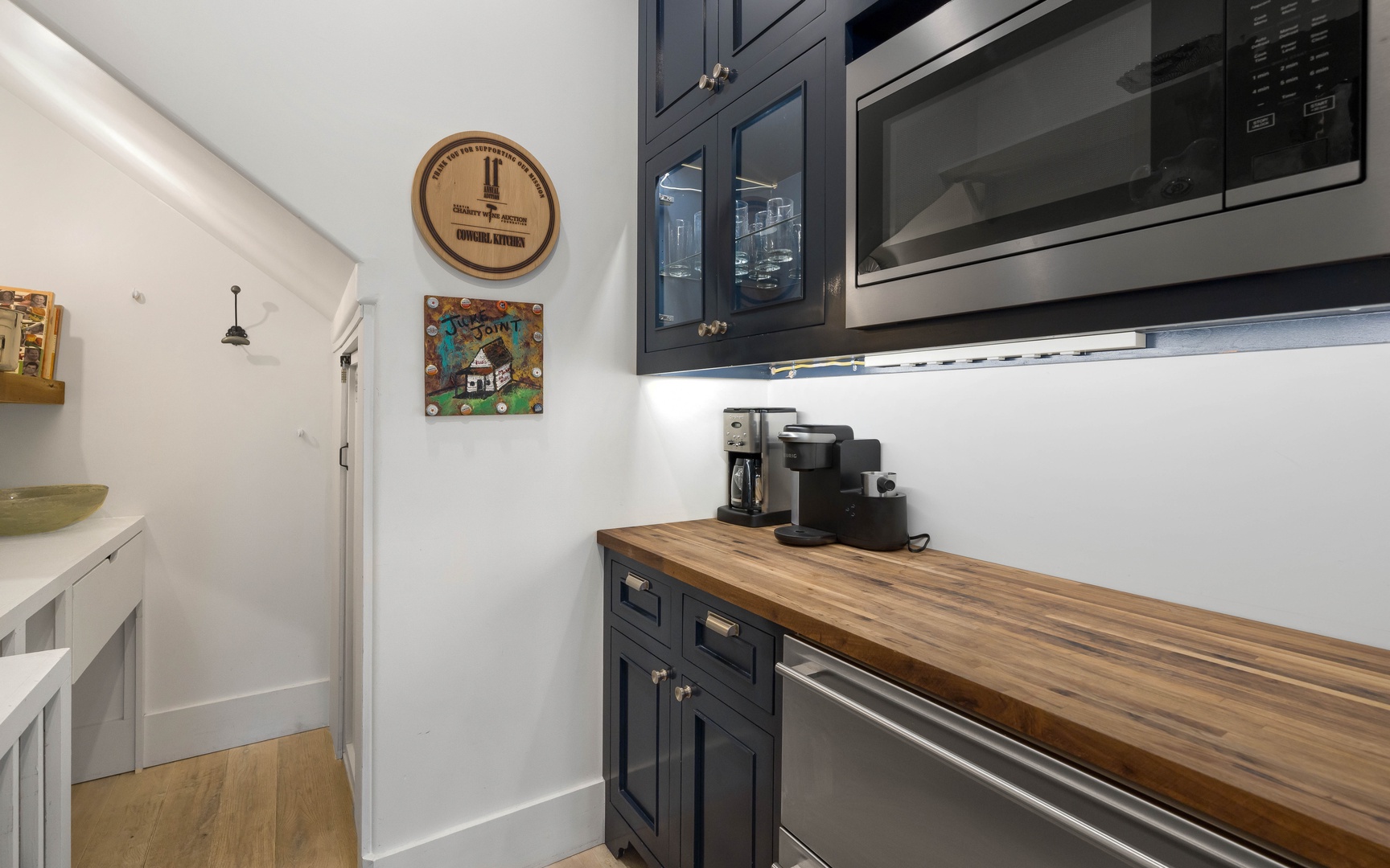 Your stylish kitchen features rich navy cabinetry, warm butcher-block counters, and premium stainless appliances ready for morning coffee.